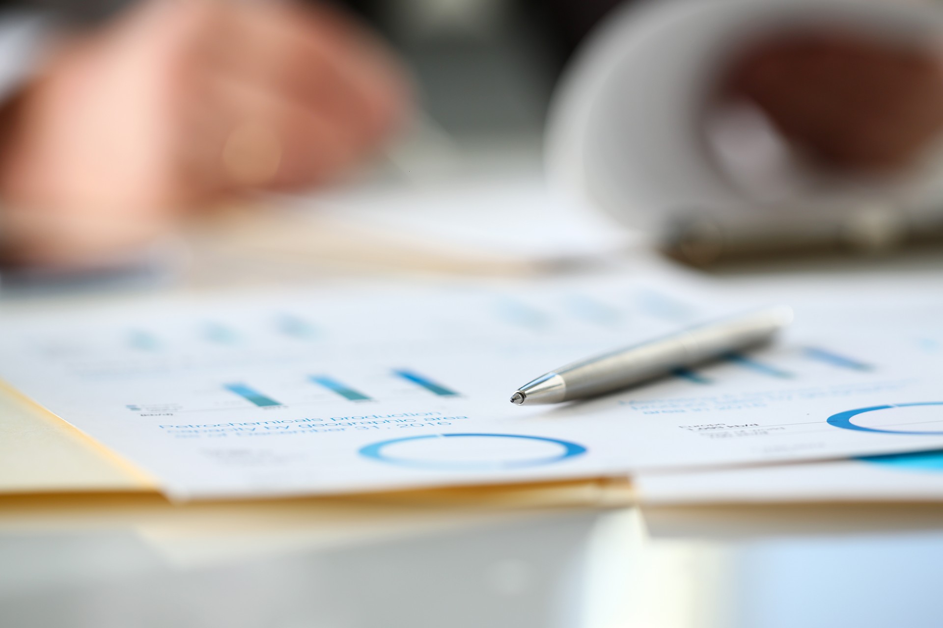 A pen resting on a piece of paper with graphs