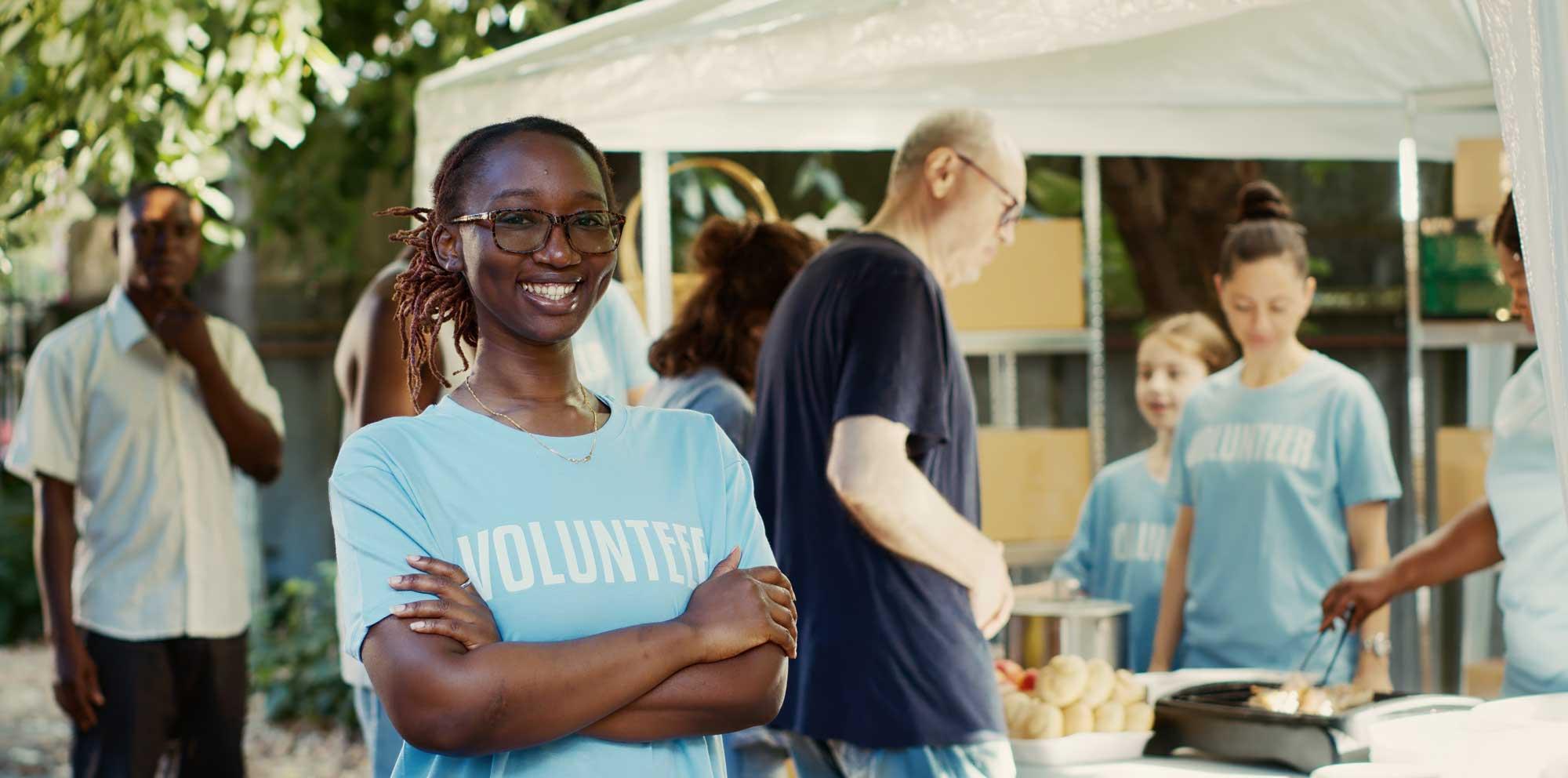 A young Black girl smiling at the camera in a volunteer area